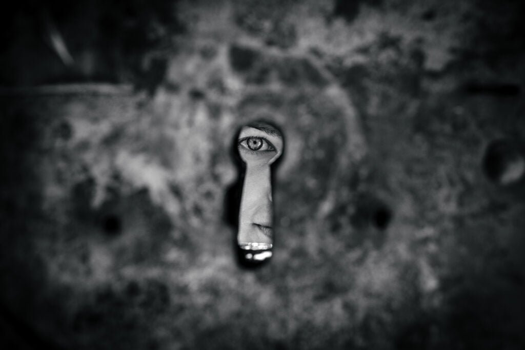 Keyhole with an eye on the other side, representing nomad journalism and slow traveling.