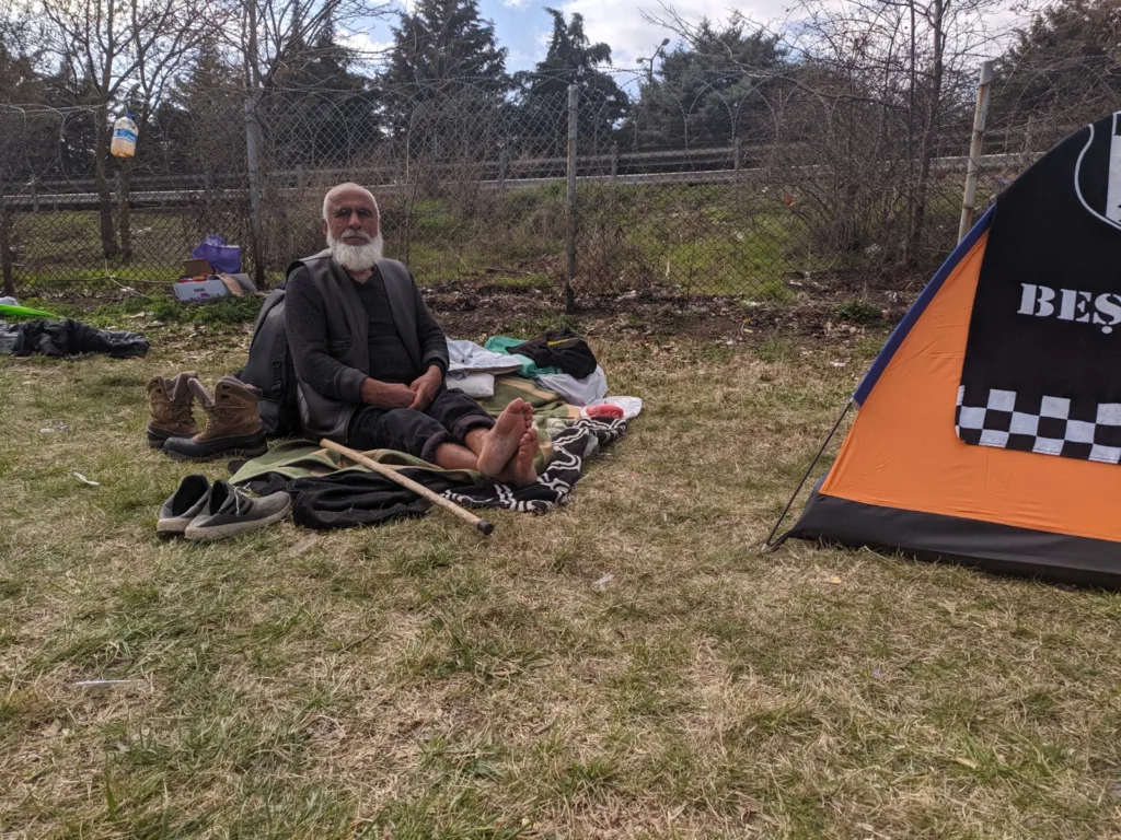 Migrant resting beside his tent